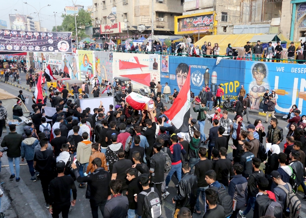 Iraqi mourners carry the coffin of Haidar Ahmed Kazem, a high school student who was killed a day earlier, during his funeral procession in Tahrir square in the capital Baghdad, on Sunday. -AFP