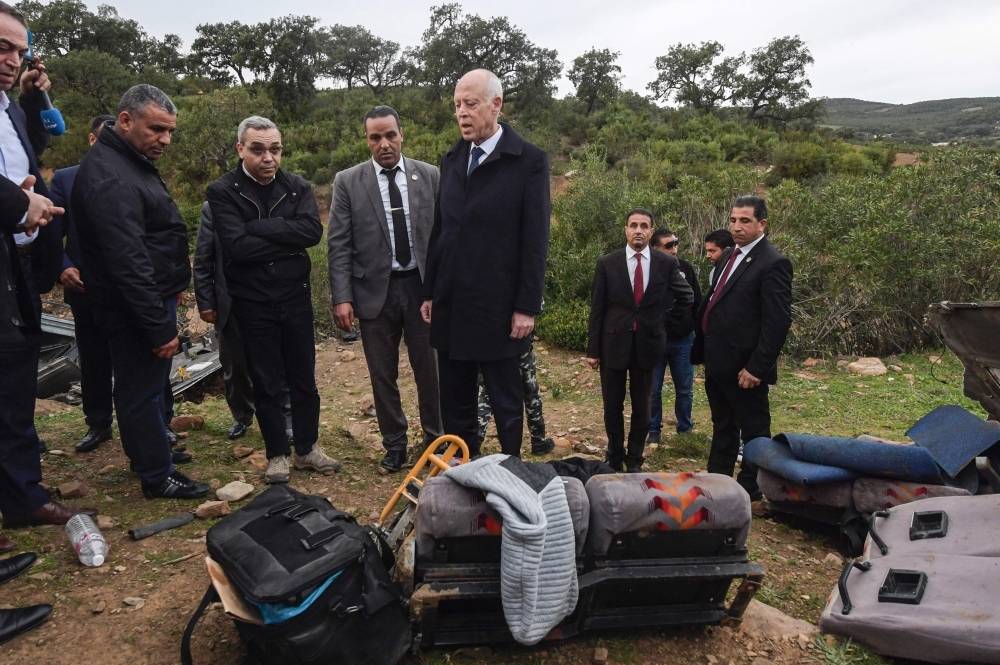 Tunisian President Kais Saied (C) speaks with officials at the scene of a road accident that saw a bus plunge over a cliff into a ravine in Ain Snoussi in northwestern Tunisia on Sunday. -AFP
