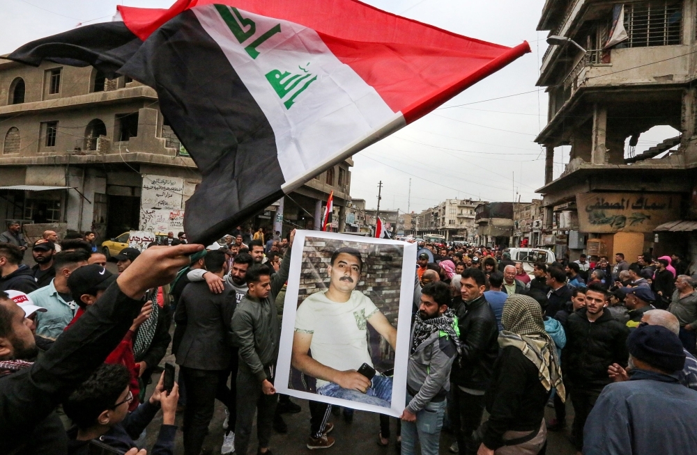 Iraqi mourners strike tambourines as they march in a funerary procession for an anti-government protester who died from injuries sustained in previous confrontations with security forces in the capital Baghdad on Tuesday. — AFP