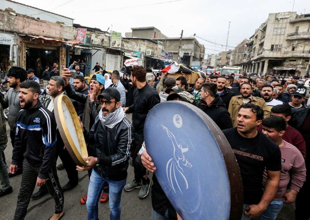 Iraqi mourners strike tambourines as they march in a funerary procession for an anti-government protester who died from injuries sustained in previous confrontations with security forces in the capital Baghdad on Tuesday. — AFP