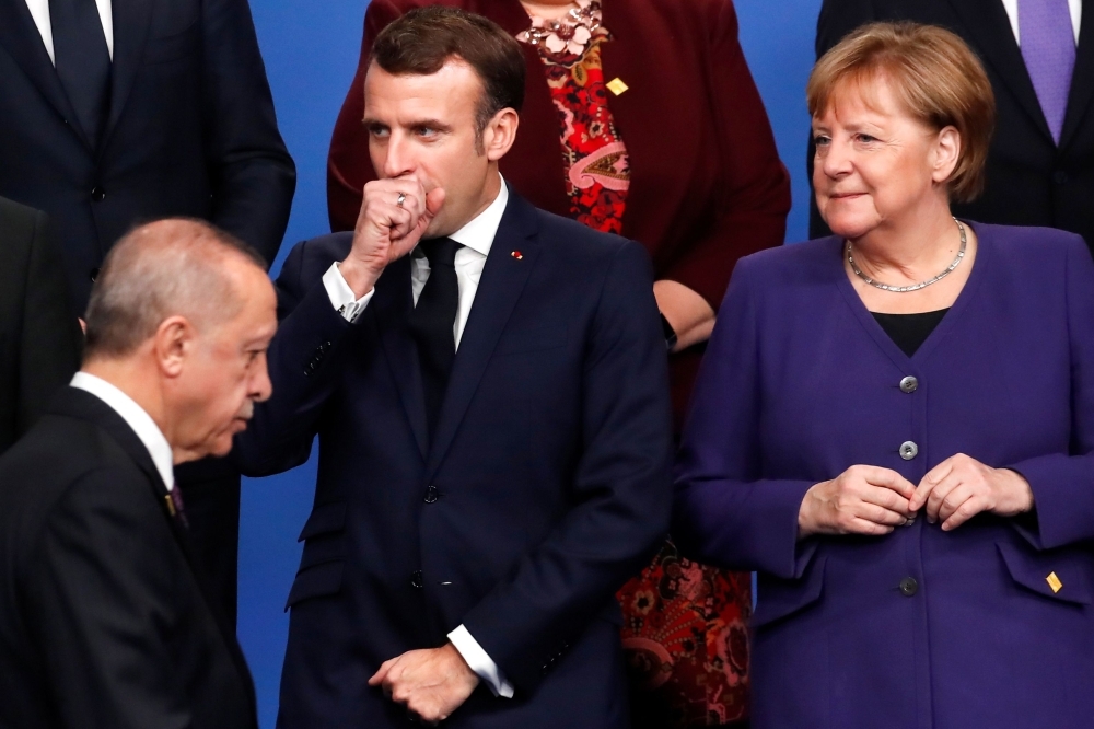 France's President Emmanuel Macron, center, gestures next to Turkey's President Recep Tayyip Erdogan, left, and Germany's Chancellor Angela Merkel during a family photo as part of the NATO summit at the Grove hotel in Watford, northeast of London, on Wednesday. — AFP