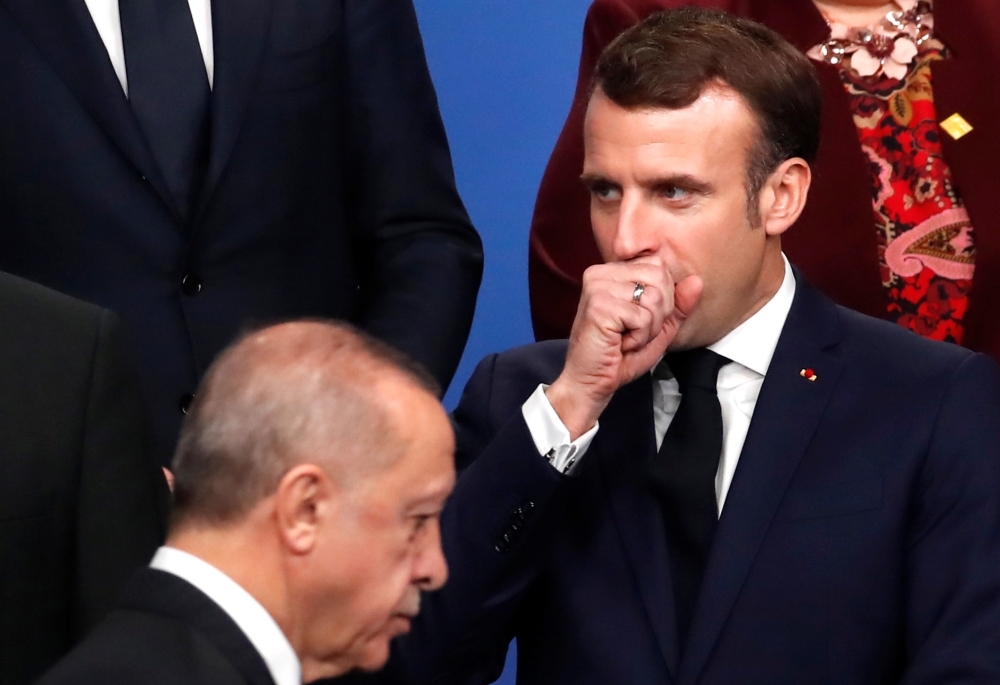 France's President Emmanuel Macron, right, gestures as Turkey's President Recep Tayyip Erdogan walks past him during a family photo as part of the NATO summit at the Grove hotel in Watford, northeast of London, on Wednesday. — AFP