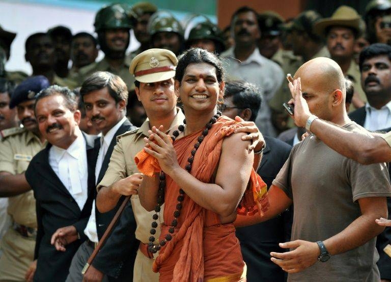 Police escort controversial Hindu Godman Swami Nityananda, center, in 2012 after he appeared at a bail hearing in Ramanagar District, some 50 km from Bangalore, India. — AFP