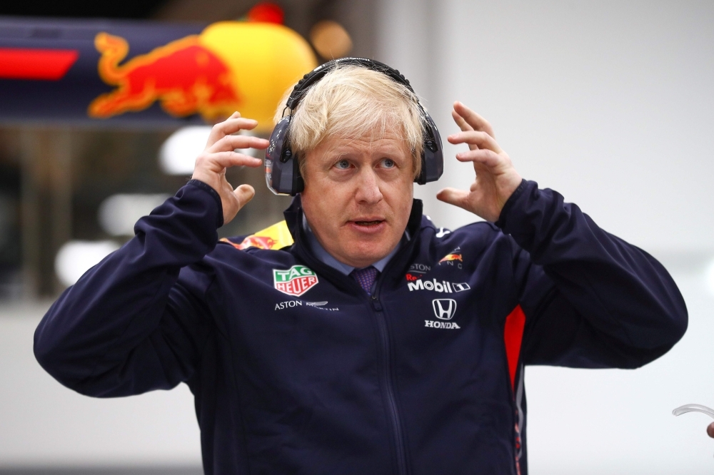 Britain's Prime Minister Boris Johnson dons protective safety wear as he prepares to change a wheel of a Formula One (F1) race car during a Conservative Party general election campaign visit to Red Bull Racing in Milton Keynes, north of London, on Thursday. — AFP