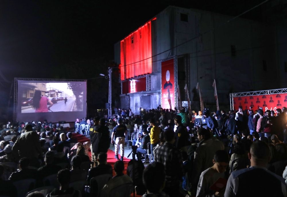 Palestinians watch a film during the opening ceremony of the Red Carpet Human Rights Film Festival in Gaza-Karama Palestine, in front of the abandoned Cinema Amer building in Gaza City, on Wednesday. — AFP