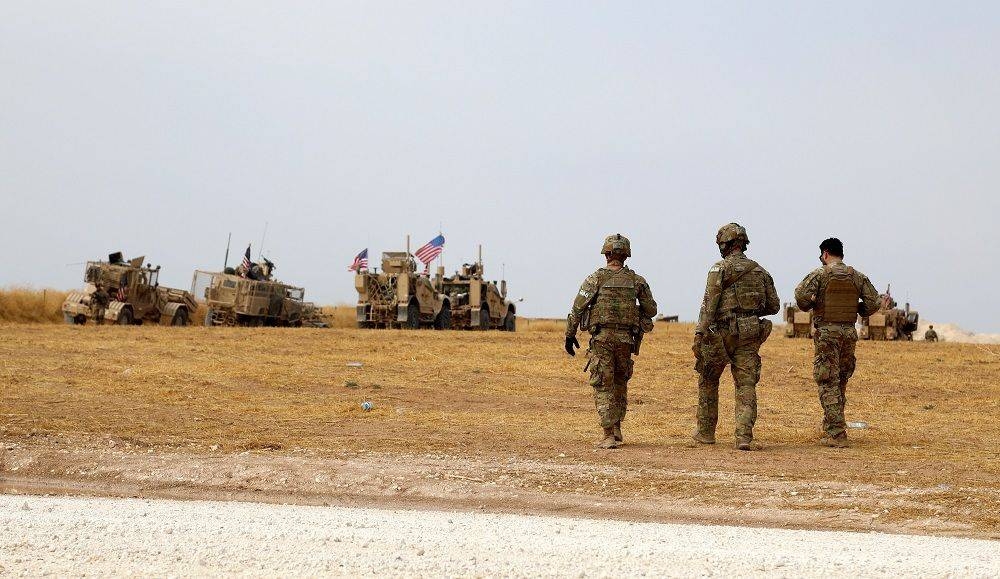 US soldiers walk next their armed trucks in Iraq in this file picture. — Courtesy photo