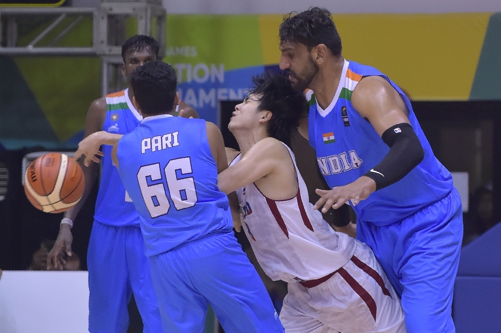 In this file photo taken on Feb. 8, 2018, Attapong Leelaphipatkul [white No. 98) of Thailand vies for the ball against Akilan Pari (No. 66) and Satnam Singh Bhamara (R) of India during the basketball round robin at the test event for 2018 Asian Games in Jakarta. Satnam Singh, the first Indian to be drafted into the NBA, has been provisionally suspended by India's anti-doping agency after failing a drug test last month. — AFP