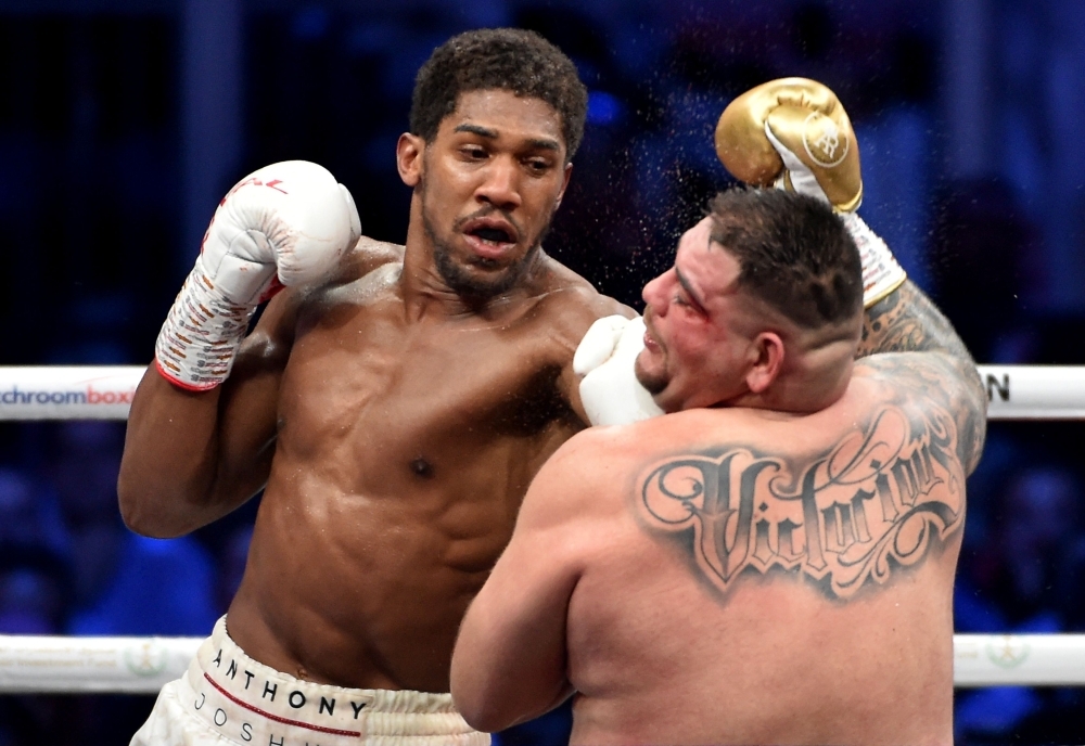 British boxer Anthony Joshua celebrates after winning the heavyweight boxing match between Andy Ruiz Jr. and Anthony Joshua for the IBF, WBA, WBO and IBO titles in Diriyah, near the Saudi capital Riyadh, on Saturday. Joshua reclaimed his world heavyweight crown from Andy Ruiz, outclassing the Mexican-American to score a unanimous points victory. — AFP