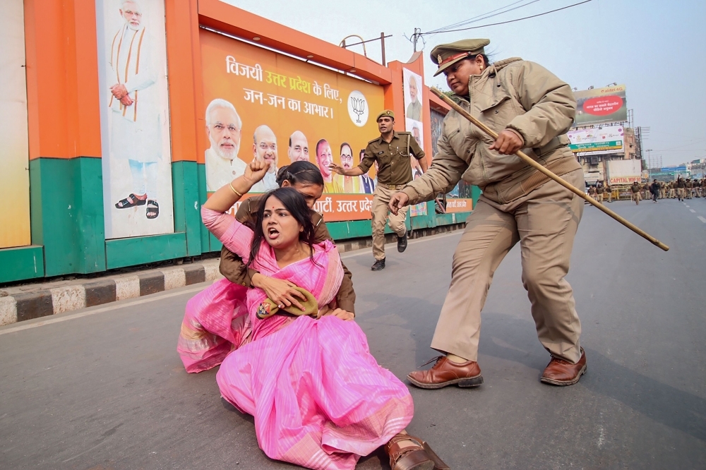 A Samajwadi Party activist, center in pink, is being held by police personnel as she protests against the Unnao rape case during a demonstration at Vishan Sabha, the seat of the legislature of Uttar Pradesh state, in Lucknow in this Dec. 7, 2019 file photo. — AFP