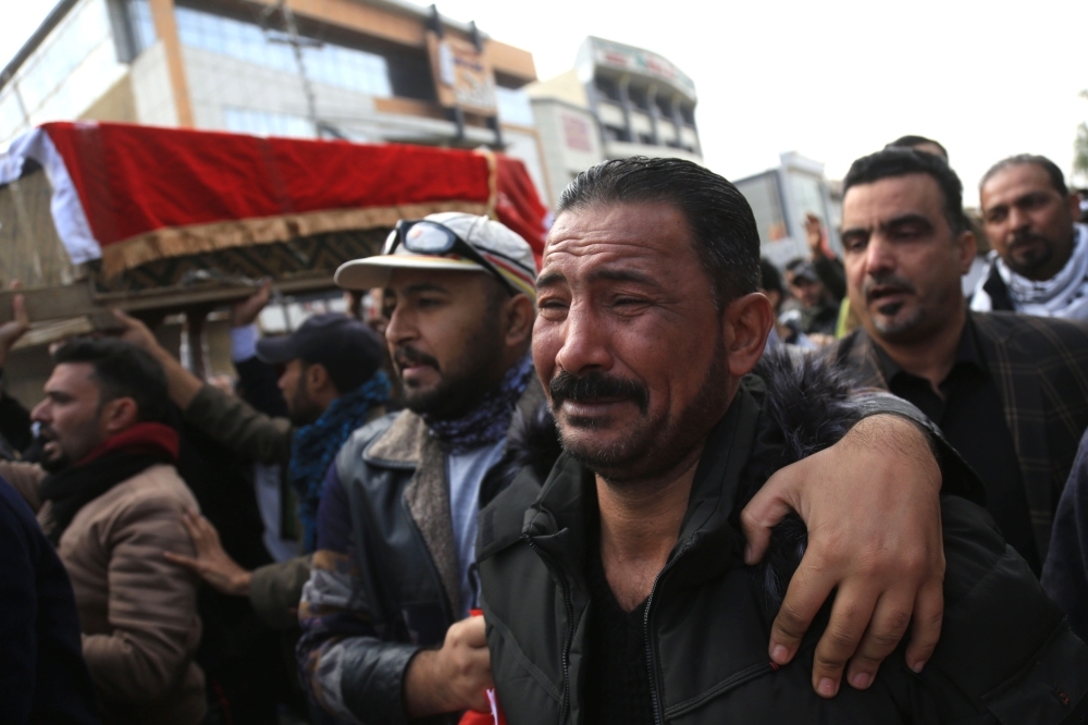 An Iraqi mourner cries as he joins the crowd walking in the funeral of a prominent civil society activist who was shot dead the previous night while returning home from anti-government protests, in Iraq's shrine city of Karbala, south of the capital Baghdad, on Monday. — AFP