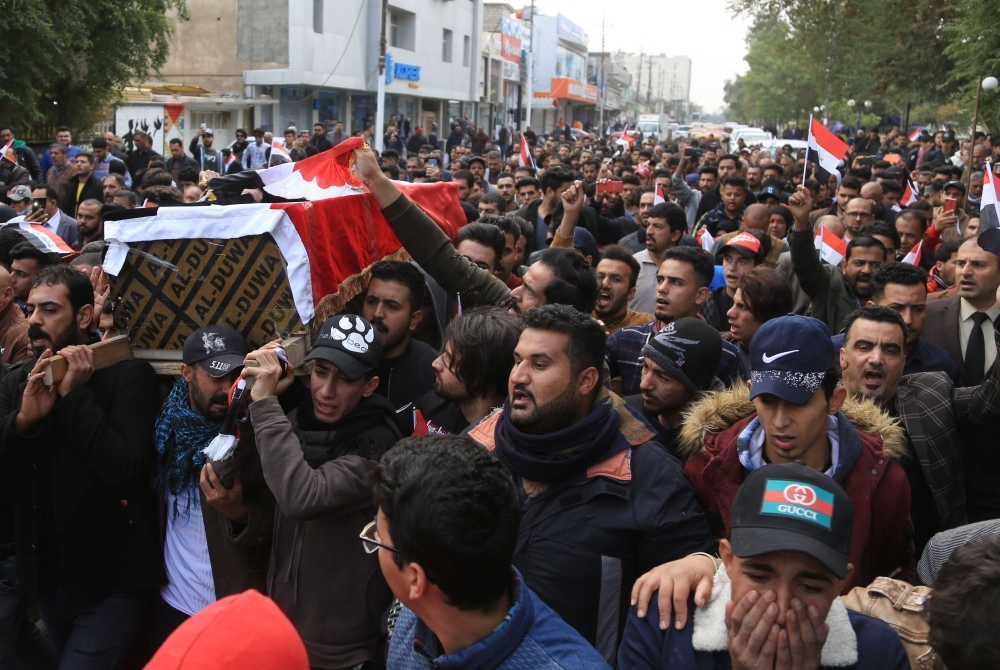 An Iraqi mourner cries as he joins the crowd walking in the funeral of a prominent civil society activist who was shot dead the previous night while returning home from anti-government protests, in Iraq's shrine city of Karbala, south of the capital Baghdad, on Monday. — AFP