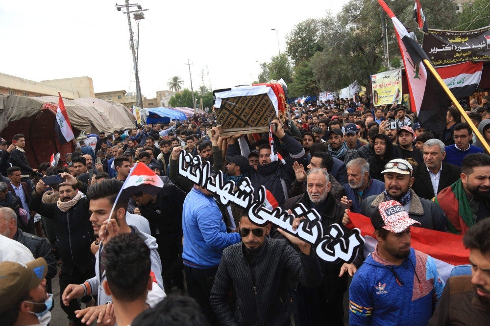 An Iraqi mourner cries as he joins the crowd walking in the funeral of a prominent civil society activist who was shot dead the previous night while returning home from anti-government protests, in Iraq's shrine city of Karbala, south of the capital Baghdad, on Monday. — AFP