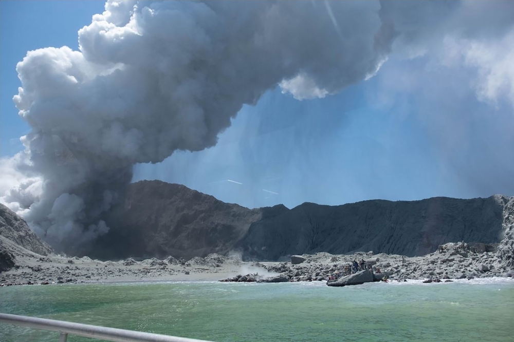 This handout photograph courtesy of Michael Schade shows the volcano on New Zealand's White Island spewing steam and ash minutes following an eruption on Monday. — AFP