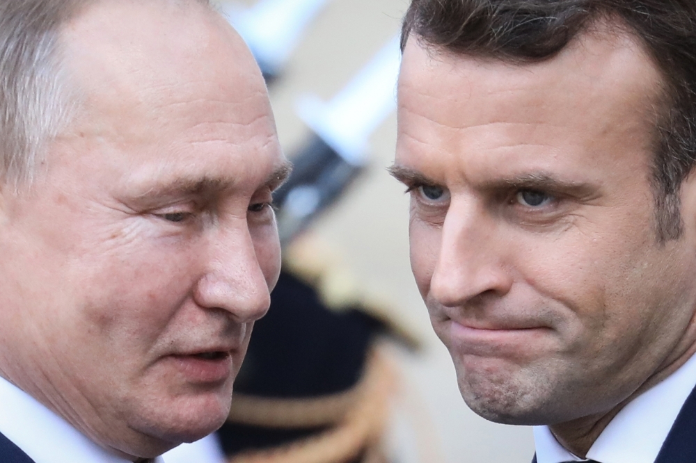 French President Emmanuel Macron, right, welcomes Russian President Vladimir Putin upon his arrival at the Elysee Palace to attend a summit on Ukraine in Paris on Monday. — AFP