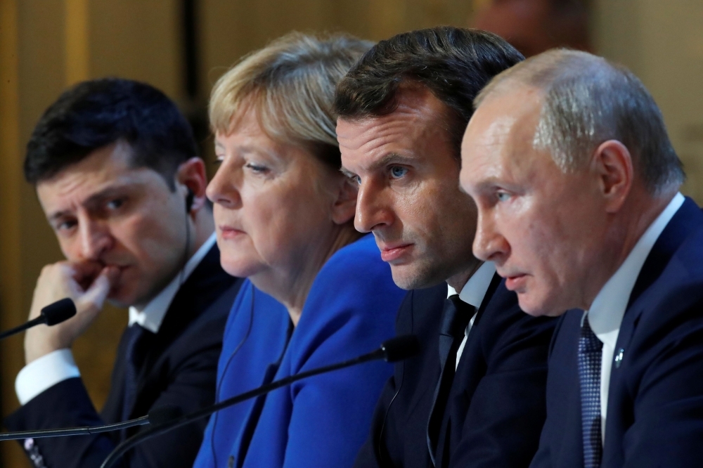 Ukraine's President Volodymyr Zelenskiy, German Chancellor Angela Merkel, French President Emmanuel Macron and Russia's President Vladimir Putin attend a press conference after a summit on Ukraine at the Elysee Palace, in Paris, on Monday. -AFP