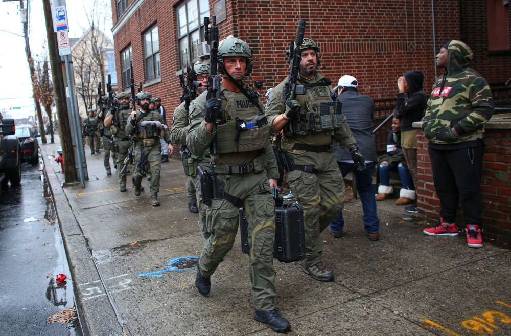 Residents are kept back as emergency personnel work the scene of a shooting that left multiple people dead in Jersey City, New Jersey, on Tuesday. — AFP