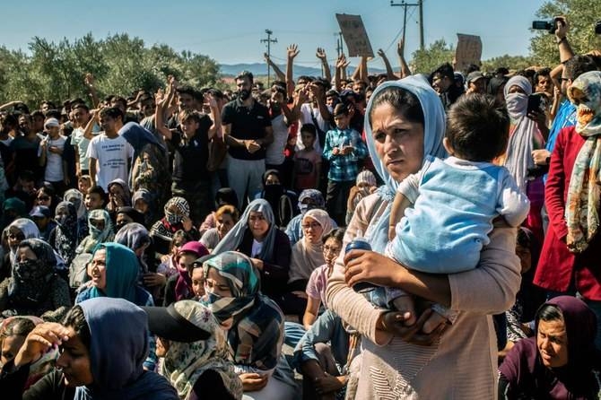 A woman holds a baby as refugees and migrants take part in a demonstration against their living conditions at the Moria camp on the island of Lesbos, Greece, in this Oct. 1, 2019 file photo. — AFP