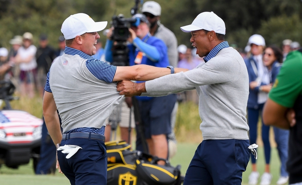 US players Justin Thomas (L) and Tiger Woods (R) celebrate winning the match during the second day of the Presidents Cup golf tournament in Melbourne on Friday. — AFP