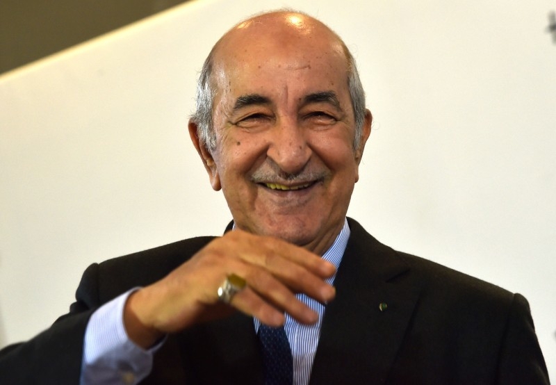 Algerian President-elect Abdelmadjid Tebboune waves to greet attendees during a press conference in the capital Algiers on Friday. — AFP