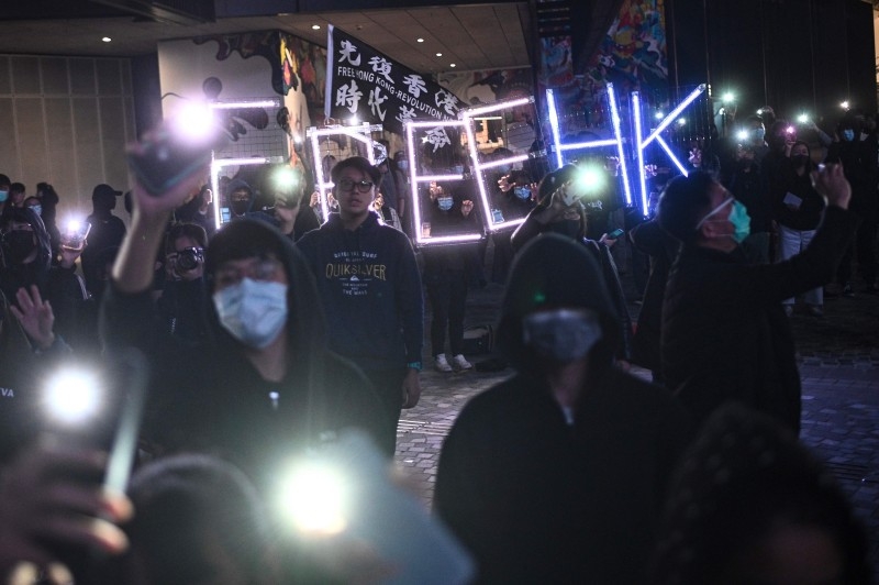 A light installation of 'Free HK' is presented while high school students light up their mobile phones as they sing 'Glory to Hong Kong' during a pro-democracy rally at the Salisbury Garden in Tsim Sha Tsui district of Hong Kong on Friday. -AFP