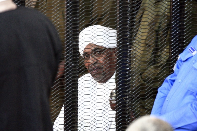 A supporter of deposed Sudanese president Omar Al-Bashir shouts and waves the national flag during a rally after his conviction of graft, outside a court in the capital Khartoum, on Saturday. -AFP