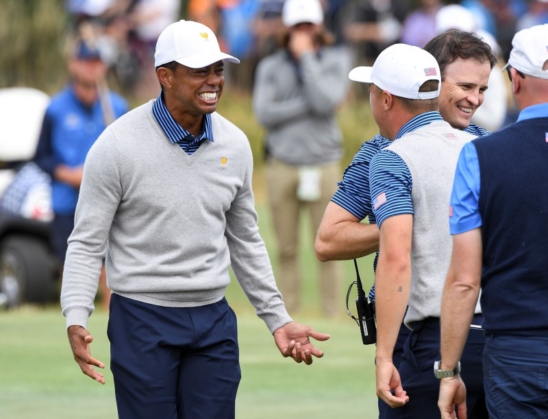 US players Justin Thomas (R-white cap) and Tiger Woods (L) celebrate winning the match during the second day of the Presidents Cup golf tournament in Melbourne on Friday. — AFP