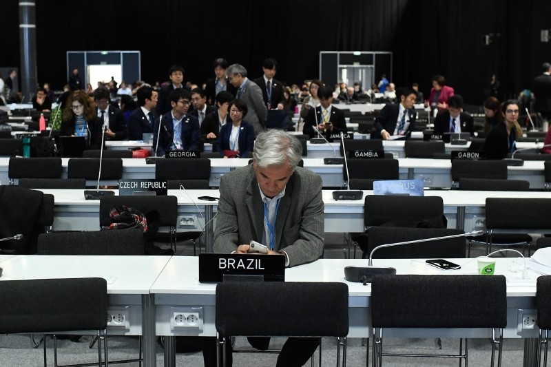 Delegates wait for the start of the closing plenary session of the UN Climate Change Conference COP25 at the 'IFEMA - Feria de Madrid' exhibition centre, in Madrid, on Sunday. -AFP