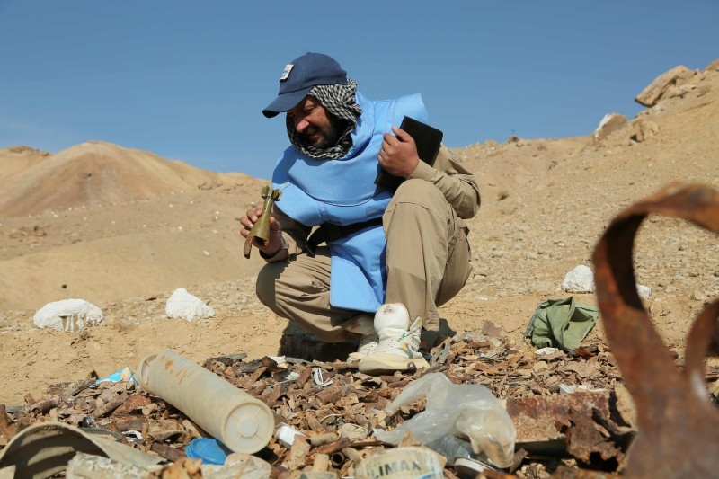 In this photograph taken on November 14, 2019, Afghan deminers working for the Danish Demining Group (DDG) look on during the scanning of a combat zone dating back to the Soviet invasion at Ahangaran in the central afghan province of Bamiyan. -AFP