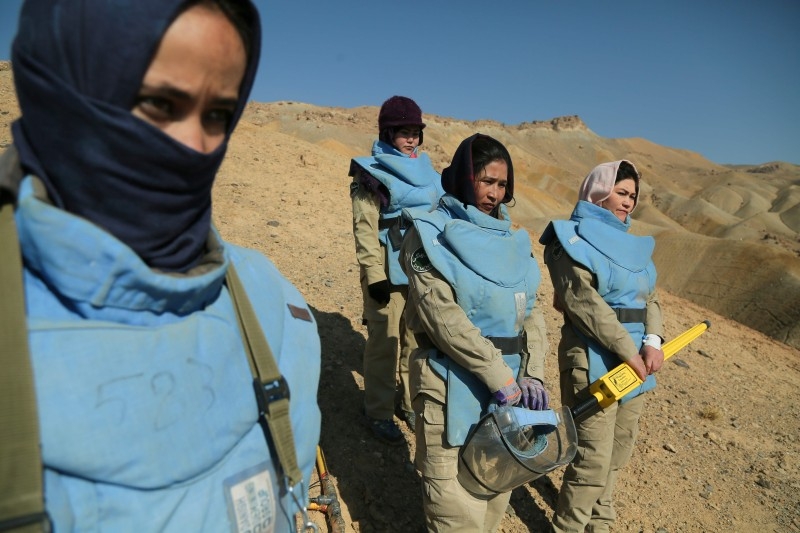 In this photograph taken on November 14, 2019, Afghan deminers working for the Danish Demining Group (DDG) look on during the scanning of a combat zone dating back to the Soviet invasion at Ahangaran in the central afghan province of Bamiyan. -AFP