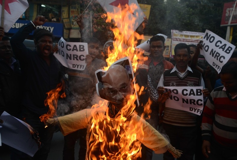  Indian left wing activists of Democratic Youth Federation of India (DYFI) shout slogans as they burn an effigy of India's Home Minister Amit Shah during a demonstration against the Indian government's Citizenship Amendment Bill in Siliguri on Saturday. -AFP