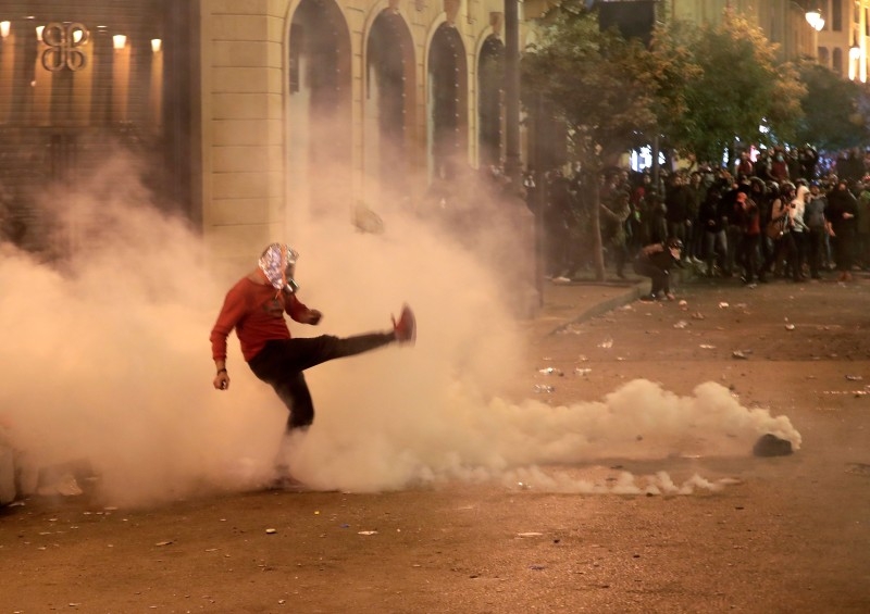 A Lebanese demonstrator kicks back a tear-gas canister during clashes with riot police in the capital Beirut on Sunday. -AFP