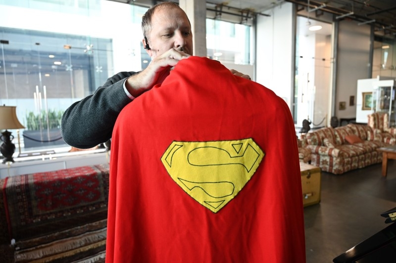 Julien's Auctions Jason DeBord adjusts an original Superman cape worn by actor Christopher Reeve in the 1978 