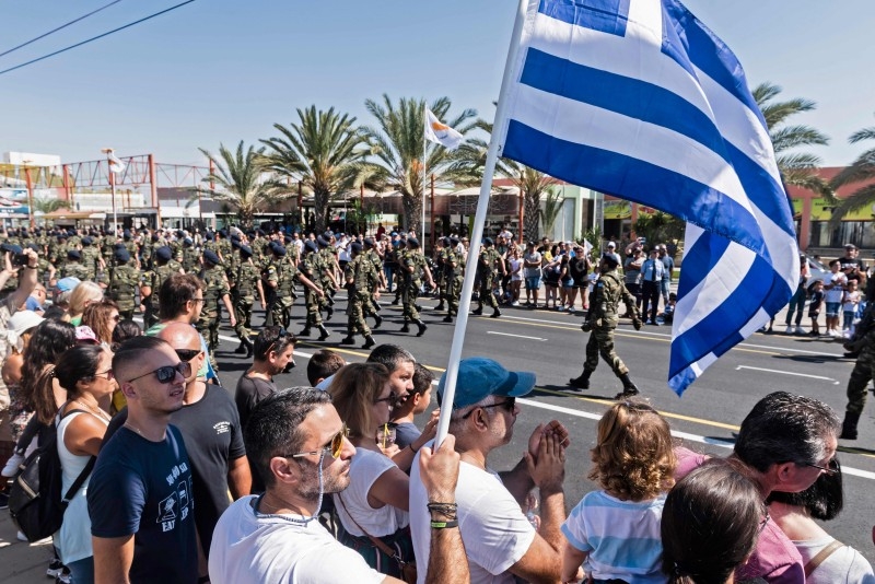  In this file photo taken on October 1, 2019 a man waves a Greek national flag as Cypriots attend a military parade marking the 59th anniversary of Cyprus' independence from British colonial rule, in the capital Nicosia. -AFP