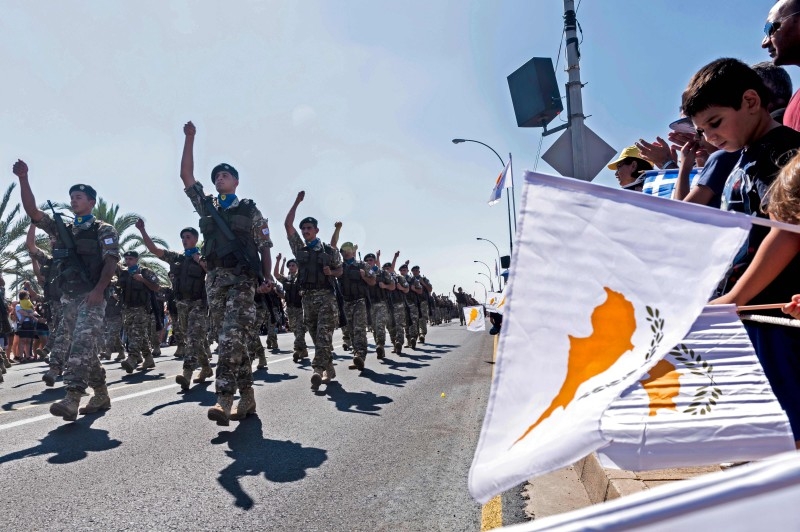  In this file photo taken on October 1, 2019 a man waves a Greek national flag as Cypriots attend a military parade marking the 59th anniversary of Cyprus' independence from British colonial rule, in the capital Nicosia. -AFP