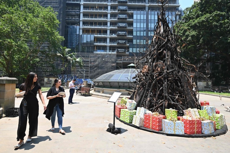 People look at an installation dubbed 'the Burnt Christmas Tree' to support the Australian Red Cross’ Disaster Relief and Recovery Fund in Sydney on Wednesday  in the wake of the bushfire situation across the state. -AFP