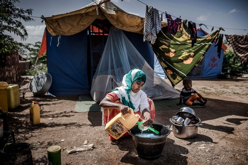 A displaced woman, who was forced to leave her house due to heavy rains and floods in the area, cooks a meal at a displacement camp for families affected by floods located in Beledweyne, Somalia, on December 14, 2019. -AFP