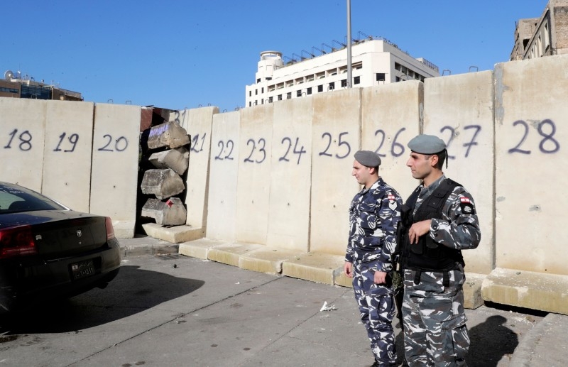 People walk through concrete barricades that were erected overnight to block or control access to protest sites, following attacks by counter-demonstrators, in the capital Beirut, on Wednesday. — AFP