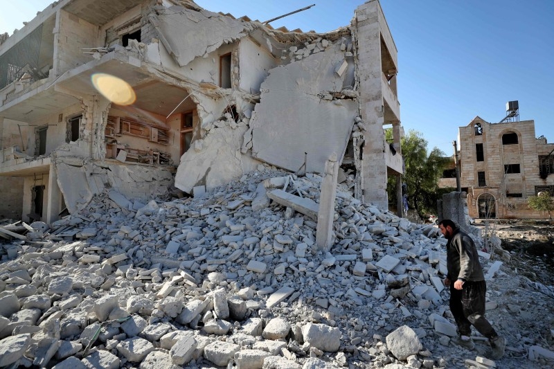A man check debris following a reported Syrian government air strike on a residential district of Maaret Al-Numan in the northwestern Idlib province on Wednesday. — AFP