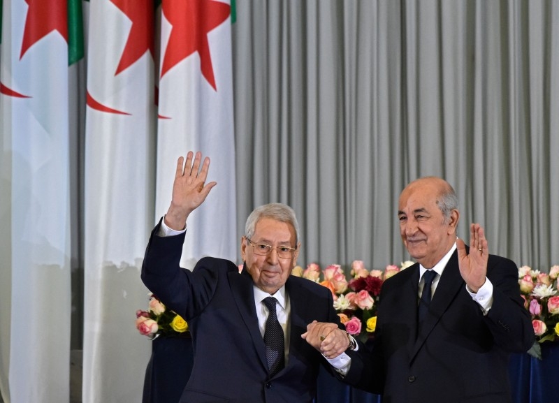 Algerian President-elect Abdelmadjid Tebboune, right, and interim president Abdelkader Bensalah wave during the formal swearing-in ceremony in the capital Algiers on Thursday. — AFP