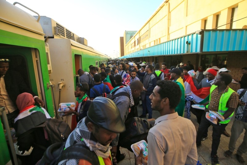 Sudanese protesters wait at a train station in Khartoum to board a train to Atbara on Thursday to celebrate the one-year anniversary of their protest movement that brought down Omar Bashir last April after a thirty-year rule. — AFP