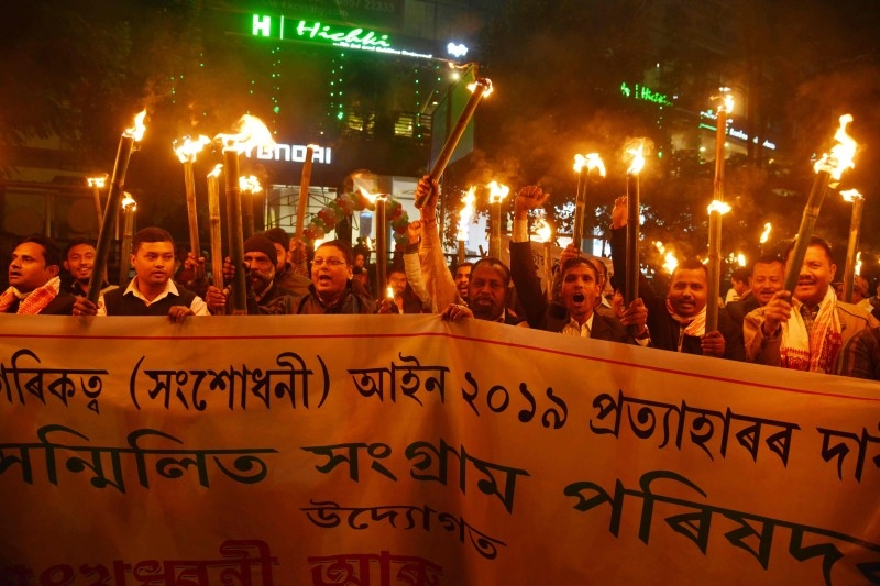Protesters shout slogans during a torch light procession in protest against India's new citizenship law in Guwahati, Assam, on Friday. — AFP