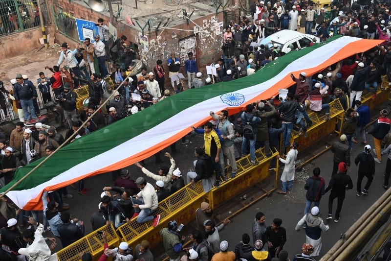  Protesters stand with a large Indian flag by the Jama Masjid mosque at a demonstration against India’s new citizenship law in New Delhi on Friday. -AFP