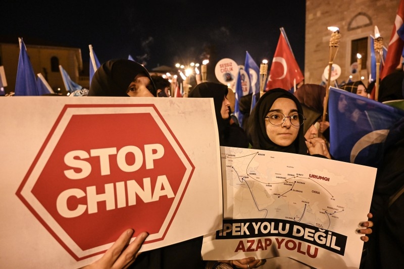 Supporters of China's Muslim Uighur minority wave flag of East Turkestan and hold placards Friday during a demonstration at Fatih in Istanbul.  -AFP