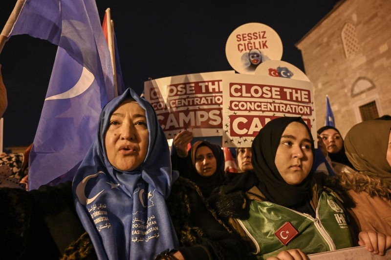 Supporters of China's Muslim Uighur minority wave flag of East Turkestan and hold placards Friday during a demonstration at Fatih in Istanbul.  -AFP