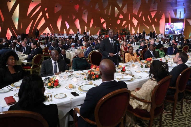 French President Emmanuel Macron (L) greets Ivorian counterpart President Alassane Ouattara on the sidelines of a press conference at the Presidential Palace in Abidjan on Saturday, during a three day visit to West Africa. -AFP