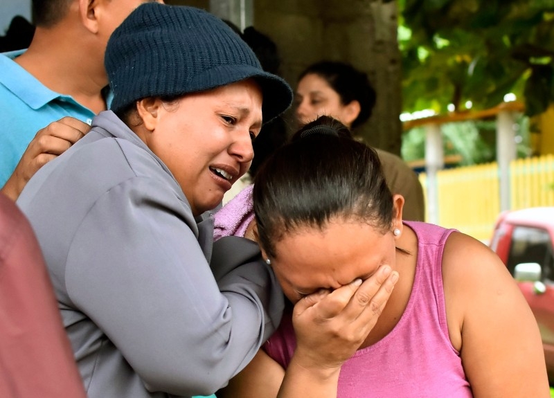 Relatives of inmates react after getting information about their loved ones in front of the penitentiary of Tela, Atlantida department, Honduras, on Saturday, following clashes occurred at the jail. -AFP