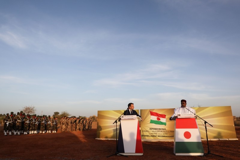  France's President Emmanuel Macron (C) and Niger's President Mahamadou Issoufou (R) take part in a military ceremony at the Martyr Quarter on Sunday, in Niamey, to pay homage to 71 Nigerien soldiers massacred in an attack on December 10 at the Inates military camp in the Sahel country's western Tillaberi region. -AFP