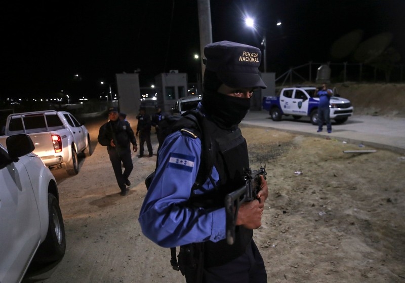 Members of Honduras' National Police patrol the entrance of El Porvenir prison, in the department of Francisco Morazan Honduras, on Sunday. -AFP