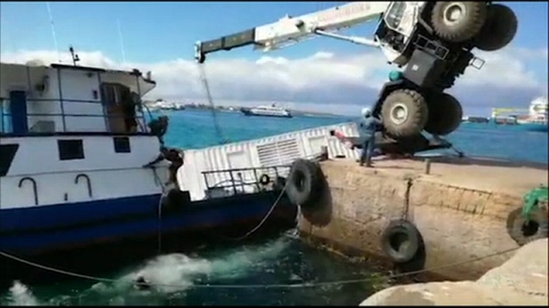 TV grab taken from a video released by the Government of Ecuador showing a crane falling on a barge carrying 600 gallons of diesel in a port on San Cristobal Island, in the Galapagos Islands, Ecuador, on December 22, 2019. -AFP