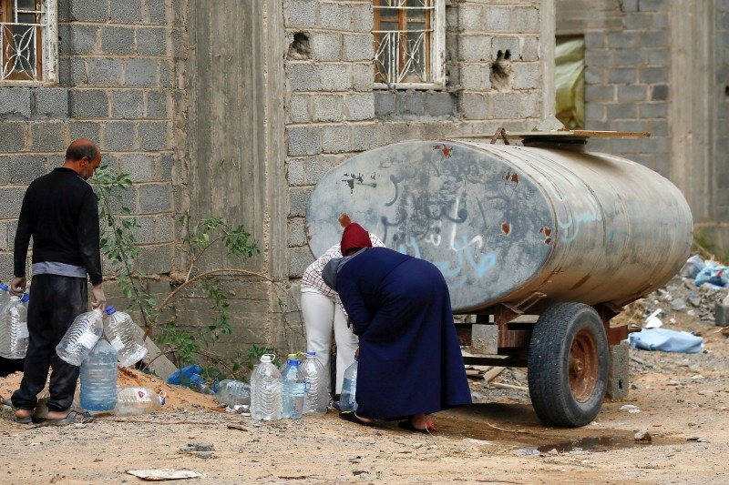 A displaced Libyan woman cleans up their room in an unfinished building in the Libyan capital Tripoli on December 18, 2019. -AFP